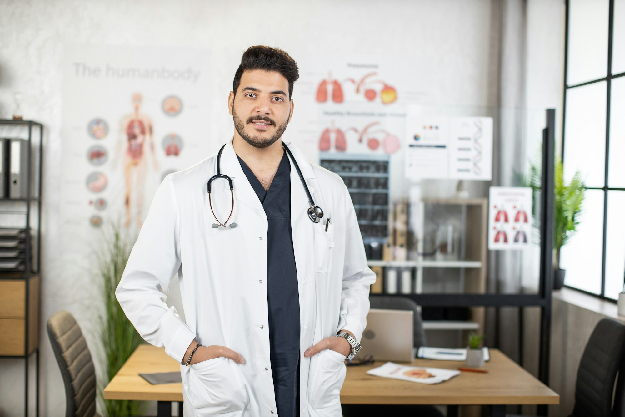 Portrait of confident indian doctor posing at cabinet